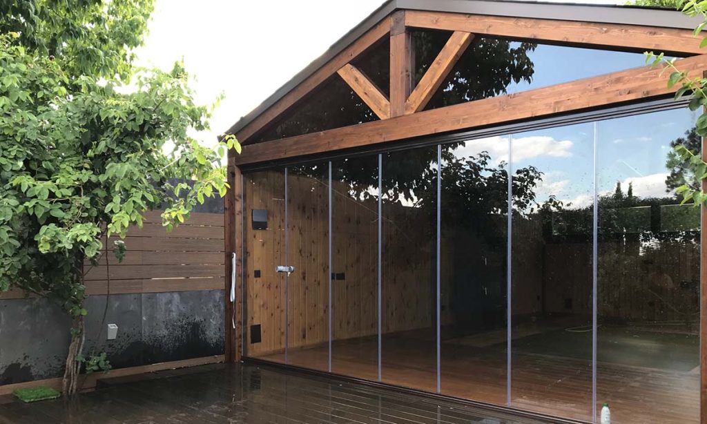 cenador de madera con cortinas de cristal